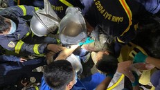 Lực lượng chức năng giải cứu người đàn ông mắc kẹt trong đống đổ nát. Ảnh: Hà Nội mới