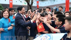 Thủ tướng Phạm Minh Chính với học sinh Trường Tiểu học Đoàn Thị Điểm. (Ảnh: Dương Giang/TTXVN)