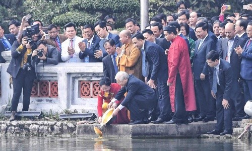 Tổng bí thư, Chủ tịch nước Nguyễn Phú Trọng cùng phu nhân thả cá chép tại hồ Hoàn Kiếm. Ảnh: Hà Trung.
