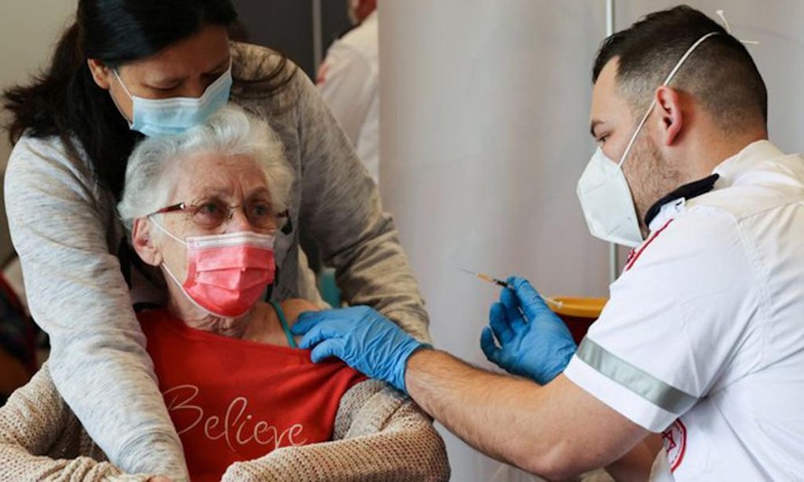 Nhân viên y tế tiêm vaccine phòng COVID-19 cho một cụ bà ở Netanya, Israel. Ảnh: Reuters.