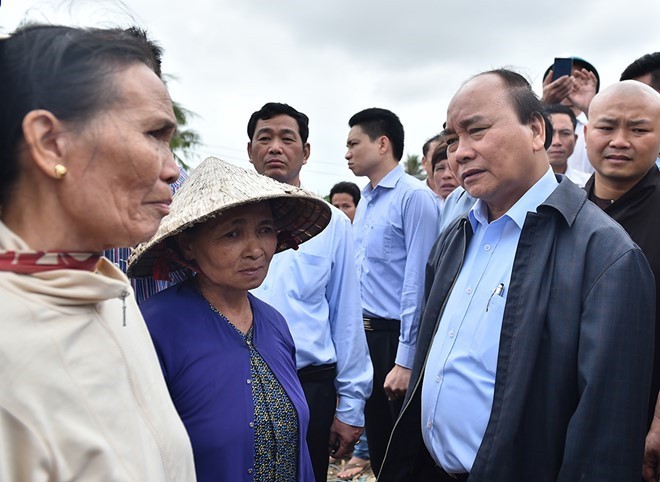 Thủ tướng Nguyễn Xuân Phúc cùng đoàn công tác thăm hỏi người dân vùng lũ ở Bình Định. Ảnh: VGP