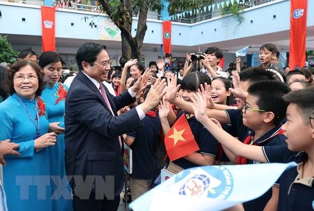 Thủ tướng Phạm Minh Chính với học sinh Trường Tiểu học Đoàn Thị Điểm. (Ảnh: Dương Giang/TTXVN)