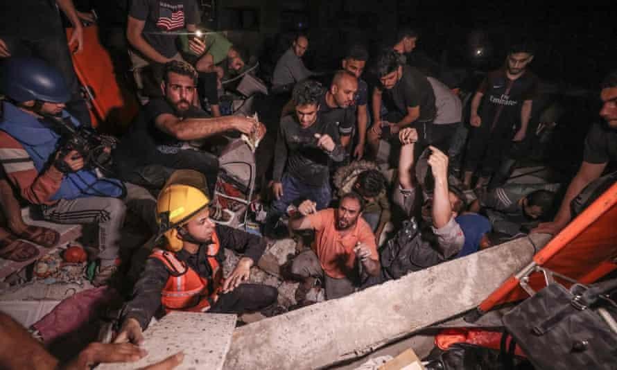 Lực lượng cứu hỏa Palestine khẩn trương tìm kiếm những người sống sót và các thi thể dưới đống đổ nát sau đợt pháo kích dữ dội vào thành phố Gaza hôm Chủ nhật. Ảnh: AFP