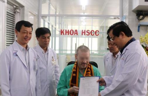 Đại diện Bộ Y tế và Bệnh viện Chợ Rẫy trao giấy xuất viện và chứng nhận âm tính với virus SARS-CoV-2 cho bệnh nhân 91 - Ảnh: TTXVN