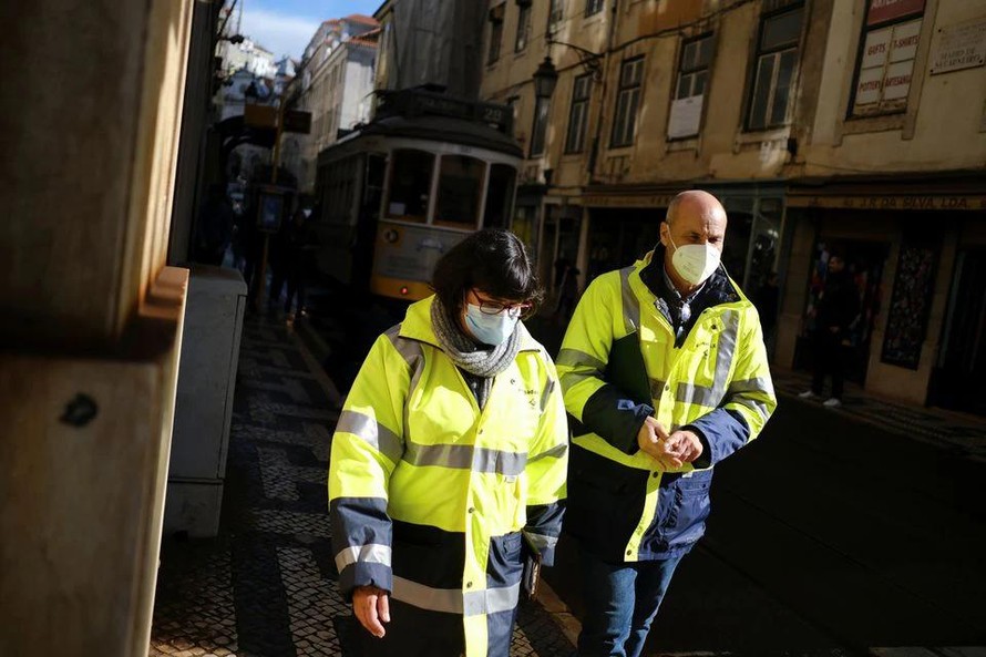 Người dân đeo khẩu trang, mặc đồ bảo hộ khi đi bộ ở trung tâm Lisbon, Bồ Đào Nha, ngày 25/11.