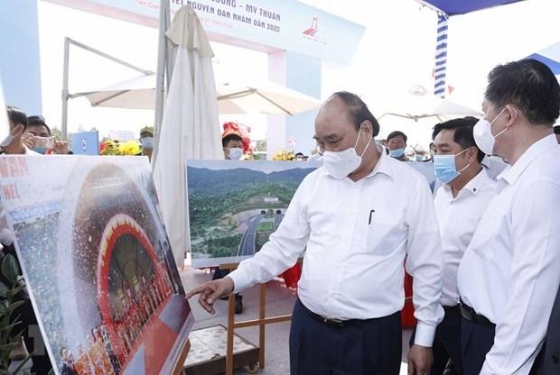Chủ tịch nước Nguyễn Xuân Phúc xem trưng bày ảnh quá trình thi công Dự án tuyến đường cao tốc Trung Lương-Mỹ Thuận. (Ảnh: TTXVN)