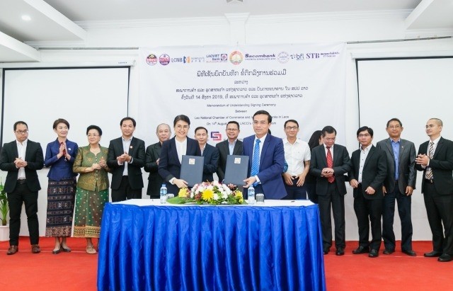 Tổng Giám đốc LaoVietBank Nguyễn Văn Bình (phải) ký Thỏa thuận với đại diện Hội đồng Thương mại và Công nghiệp quốc gia Lào.