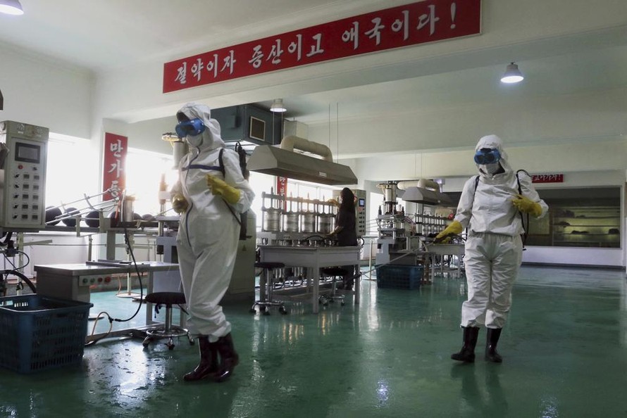 Nhân viên y tế khử trùng nhà máy ở Bình Nhưỡng, Triều Tiên. Ảnh: AP
