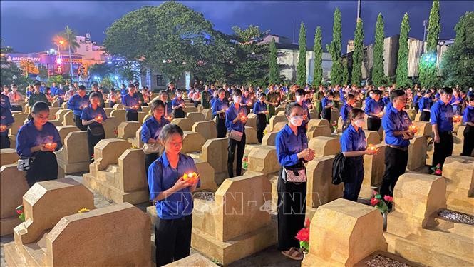 Đoàn viên thanh niên thắp nén tri ân tại các phần mộ liệt sỹ thuộc nghĩa trang liệt sỹ thành phố Quy Nhơn. Ảnh: TTXVN