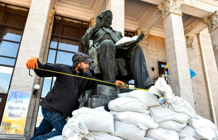 Một người đàn ông làm công việc bảo vệ bức tượng của nhà soạn nhạc người Nga Mikhail Glinka bên ngoài Phòng hòa nhạc Mikhail Glinka ở Zaporizhzhia, Ukraine. 