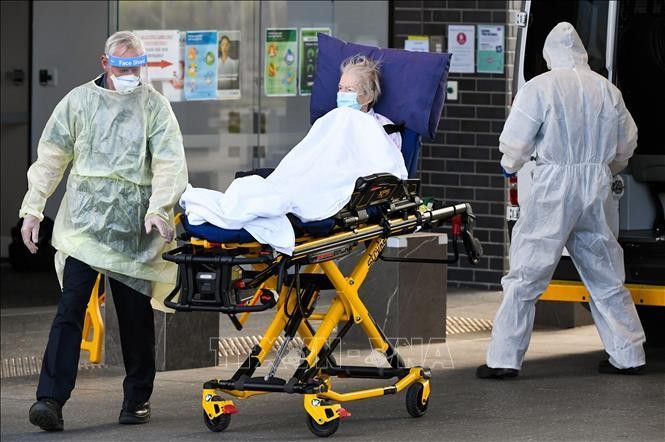 Nhân viên y tế chuyển bệnh nhân COVID-19 tại Melbourne, Australia. Ảnh: AFP/TTXVN