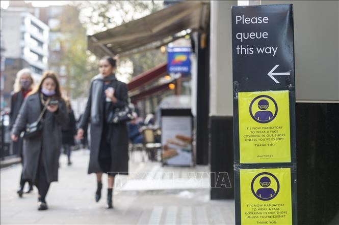 Một biển báo yêu cầu người dân đeo khẩu trang để phòng dịch COVID-19 tại London, Anh. Ảnh: THX/TTXVN