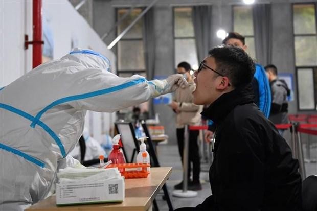 Nhân viên y tế lấy mẫu xét nghiệm COVID-19 cho người dân tại tỉnh Hồ Nam, Trung Quốc, ngày 22/3. (Ảnh: THX/ TTXVN)