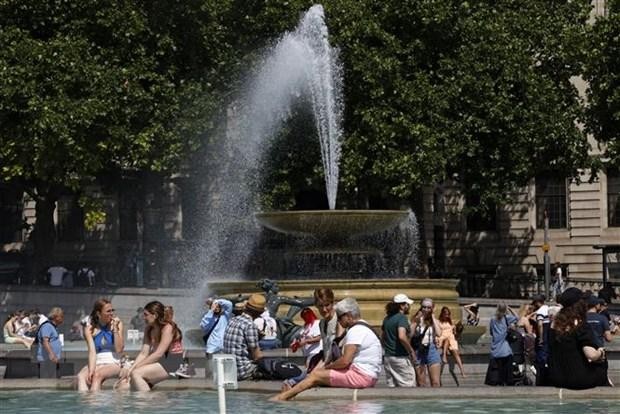 Người dân làm mát tại đài phun nước do nắng nóng gay gắt ở London, Anh ngày 17/6/2022. Theo Văn phòng khí tượng Anh, 50% khả năng nhiệt độ nước này trong ngày 18 và 19/7 sẽ lần đầu tiên vượt 40 độ C. (Ảnh: AFP/TTXVN)